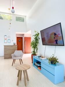a living room with a tv on a wall at Pousada Casa da Praia Angra in Angra dos Reis