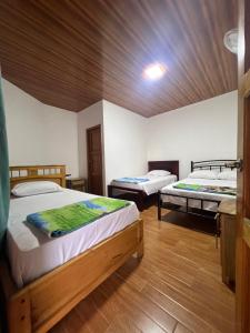 a bedroom with two beds and a wooden ceiling at Sisa Lodge in Tena