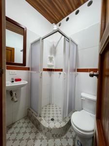 a bathroom with a shower and a toilet and a sink at Sisa Lodge in Tena