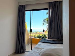 a bedroom with a bed and a large window at Hotel Pousada Casacolina in Búzios +113 photos