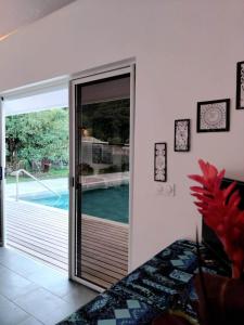 a room with a sliding glass door leading to a pool at Fare Zen Raiatea - with pool in Uturoa