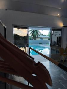 a house with a balcony with a swimming pool at Fare Zen Raiatea - with pool in Uturoa