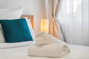 a bed with towels on it with a blue pillow at Azure beachside Escape in Marcoola