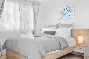 a bedroom with a bed with white pillows and a window at Azure beachside Escape in Marcoola