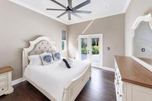 a bedroom with a large white bed with a ceiling fan at The Riverview Estates in Riverview