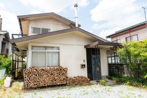 a house with a pile of firewood in front of it at Joy House in Matsumoto