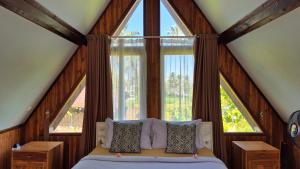 a bedroom with a bed and a large window at Green Haven Homestay in Tetebatu