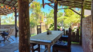 a patio with a wooden table and chairs at Green Haven Homestay in Tetebatu