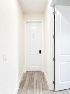 an empty white hallway with a white door at SpaceX R3 Shared in Orlando