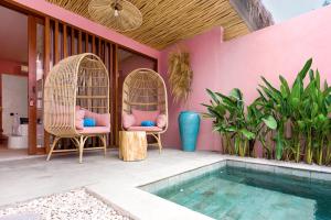 a patio with two chairs and a swimming pool at Hyde Boutique Hotel in Kuta Lombok +25 photos