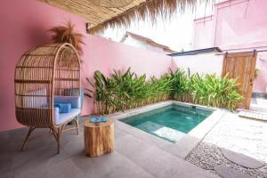 a swimming pool with a chair and a bird cage at Hyde Boutique Hotel in Kuta Lombok