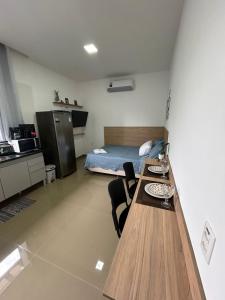 a room with a bed and a table with chairs at Studio CG Tingui 1 in Estação Inhoaíba