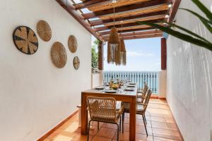 a dining room with a table and chairs and a view of the ocean at Casa Carpa Andalucia IV Carabeo Playa in Nerja