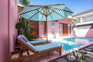 an umbrella and a chair next to a swimming pool at Hyde Boutique Hotel in Kuta Lombok