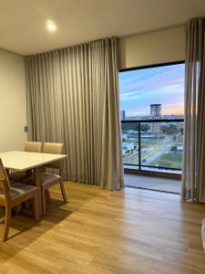 a dining room with a table and a large window at Studio Liv in Sorriso