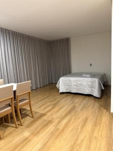a bedroom with a bed and a table and chairs at Studio Liv in Sorriso