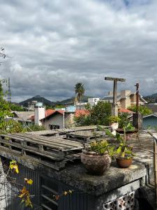 a balcony with potted plants on a ledge at Hostel e Pousada das Rosas Nova Hartz RS in Nova Hartz