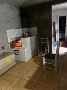a living room with a fireplace and a chair at Hostel e Pousada das Rosas Nova Hartz RS in Nova Hartz