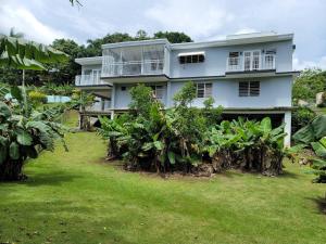 a white house with a yard in front of it at Villa in Miradero in Mayaguez