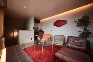 a living room with a glass table and chairs at みささ in Kyonan