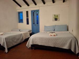 a bedroom with two beds with slippers on them at Hotel Alma Divina in Villa de Leyva