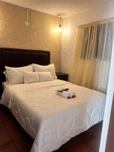 a bedroom with a white bed with white sheets at Hotel Alma Divina in Villa de Leyva