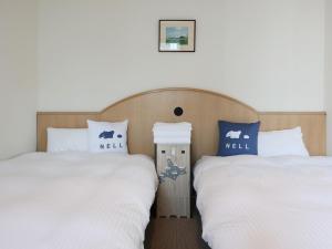 two beds sitting next to each other in a room at Tabist THE GREEN SAPPORO in Sapporo