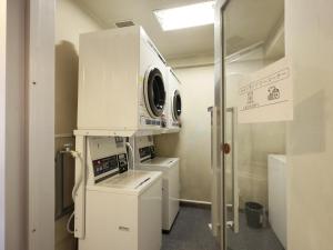a laundry room with a washer and dryer at Tabist THE GREEN SAPPORO in Sapporo