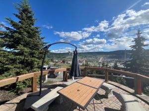 a wooden table and an umbrella on a balcony at Stampeder Inn in Williams Lake