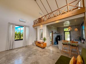 a living room with a table and chairs and a kitchen at Villa Umah Dangin Desa in Tanah Lot
