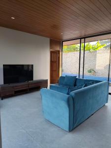 a blue couch in a living room with a television at Sonne Villa in Pangandaran