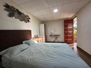 a bedroom with a large bed with blue sheets at Cabaña Moyobamba in Moyobamba
