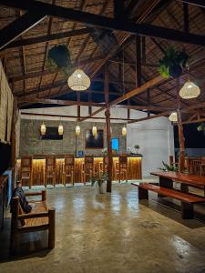 a large room with wooden tables and chairs at Jungle Vibes Hostel in San Juan