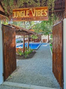 a gate to a resort with a sign that reads jungle vieves at Jungle Vibes Hostel in San Juan
