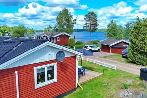 a red house with a deck and a dog in a window at "Haus Sjöholmen" in Vetlanda