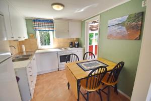 a kitchen with a table and chairs in a room at "Haus Sjöholmen" in Vetlanda