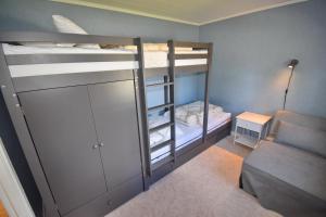 a small room with two bunk beds and a couch at "Haus Sjöholmen" in Vetlanda