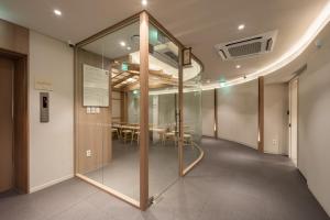 a glass partition in a room with a table at Kanso Stay Jongno in Seoul