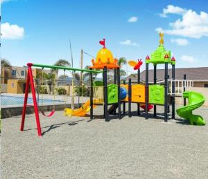 a playground with a slide and play equipment at House of Harmony in Portmore