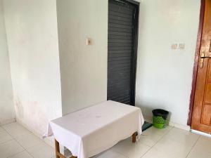 a white table in a room with a black door at LovKend in Ruteng