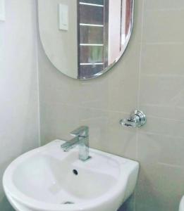 a bathroom with a white sink and a mirror at Lui my happy place in Pandan