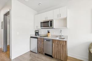 a white kitchen with a sink and a microwave at Kasa Capitol Hill Seattle in Seattle