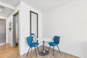 a table and two blue chairs in a room at Kasa Capitol Hill Seattle in Seattle