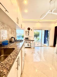 a kitchen with a sink and a counter at Luxury Villa with Pool & Garden5km from Cabo in Tétouan