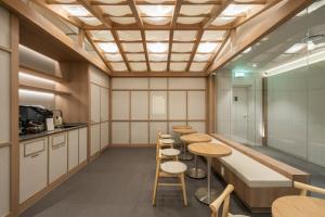 a room with tables and stools in a building at Kanso Stay Jongno in Seoul