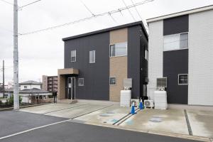 a building with a blue fire hydrant in a parking lot at Fujiyama Stay in Fujinomiya