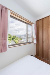 a bedroom with a bed and a large window at Fujiyama Stay in Fujinomiya