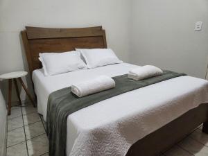 a bedroom with a bed with two pillows on it at Casa simples e funcional in Aimorés
