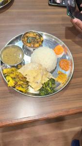a plate of food with rice and other foods on a table at Hotel Shangbola in Pāti Bhanjyāng