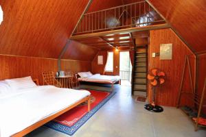 a bedroom with two beds in a wooden room at Resort Đồi Thông in Kon Von Kla